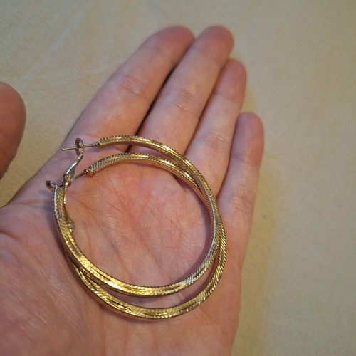 Large gold hoop earrings used with embossed texture