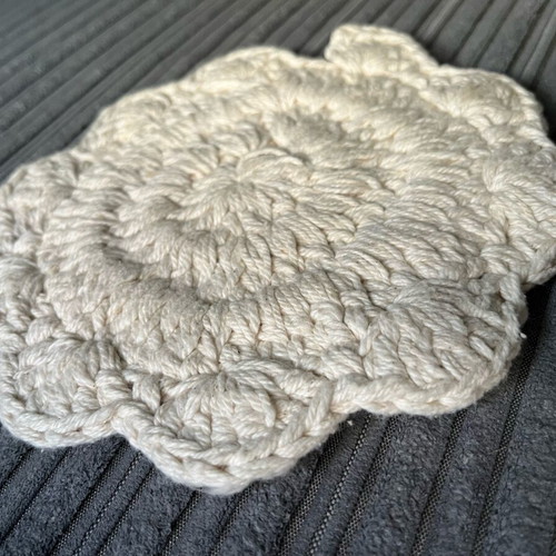 Knitted coaster used, flower-shaped, beige