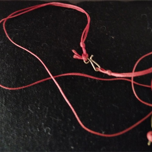 Sculpted pendant like new with square frame and red cord