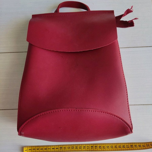 Red backpack used with broken zipper and mark