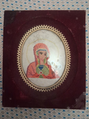 Vintage embroidery icon of Virgin Mary in velvet frame, used