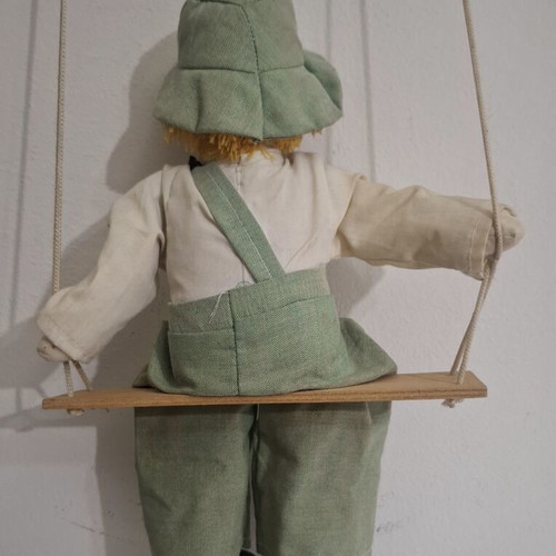 Porcelain clown doll on wooden swing, vintage collectible