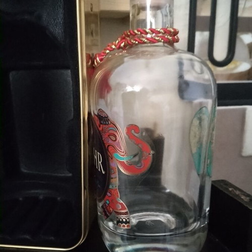 Bottle holder with collectible bottle like new, metal gold color