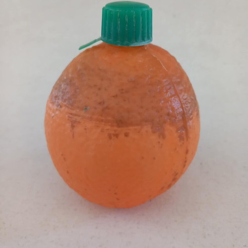 Plastic orange-shaped bottle used for beverage