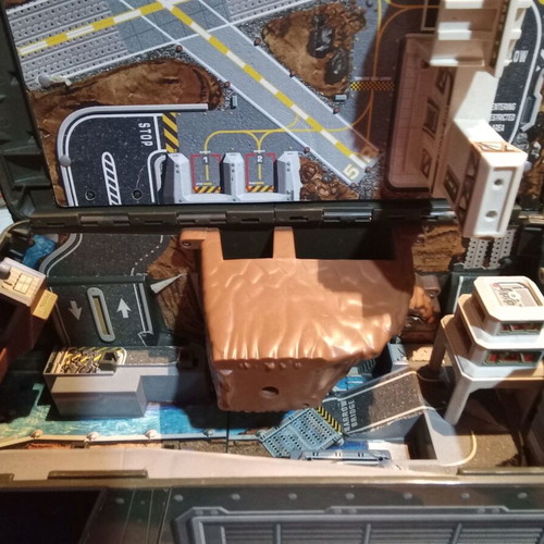 Micro machine military vehicle hiding a small city like new