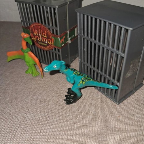 Dinosaur figures used, set in cages