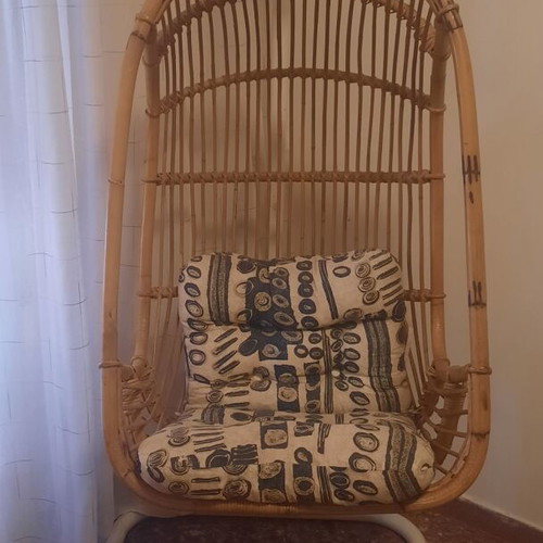 Hanging vintage armchair made of natural rattan with metal base and cushions, like new