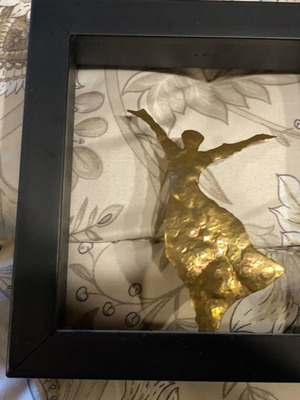 Decorative frame used with black shadow box and golden figure