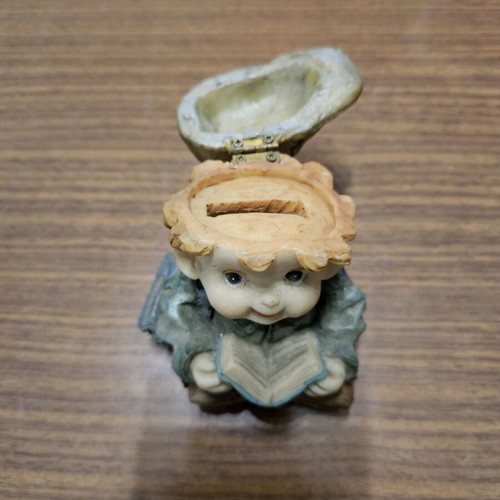 Decorative piggy bank child with book used