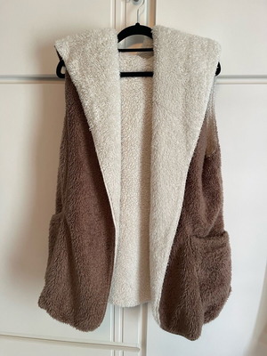 Sleeveless fur vest used in brown and white with pockets and hood