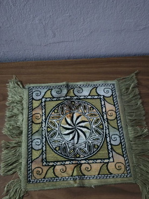 Vintage woven table mat with fringes in green and earthy tones