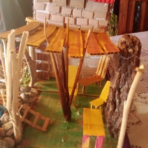 Handmade decorative house with cardboard, pebbles and driftwood, new