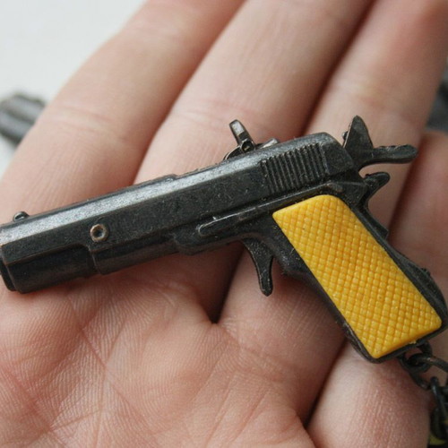 Card with 12 vintage 80's Colt 45 metal pistol keychains new