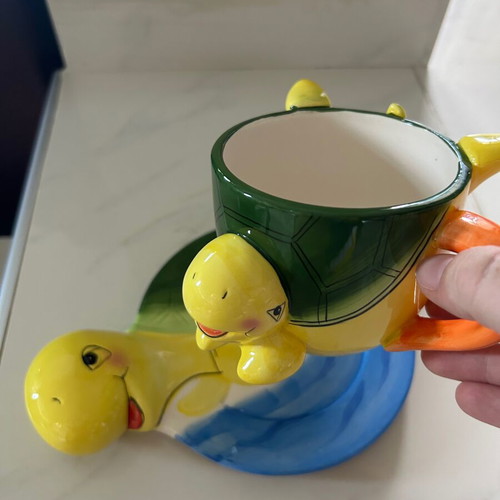 Vintage ceramic children's mug with turtle design used