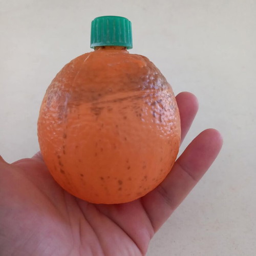 Plastic orange-shaped bottle used for beverage