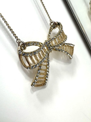 Bow-shaped necklace like new, silver with stones and gold details