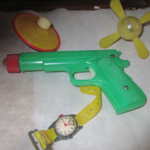 Plastic toys from the 70s like new pistol, flashlight, watch, spinning tops
