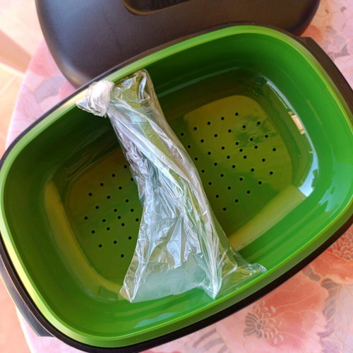 Oval Tupperware server with strainer new, black and green