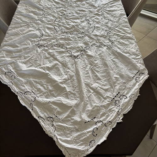Handmade tablecloth used, cotton fabric with intricate cutwork embroidery