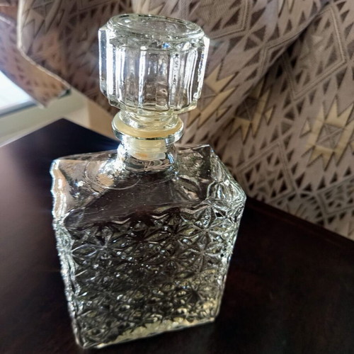 Vintage glass decanter with embossed geometric design and stopper