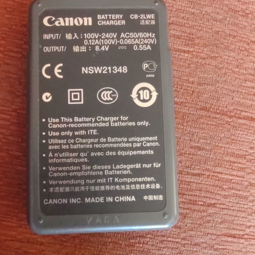 Canon EOS 400D camera used with grip, charger, and two batteries
