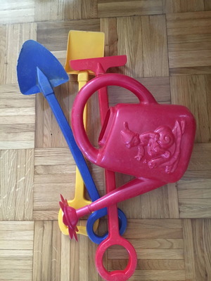 Beach toys used, watering can, shovels, rakes