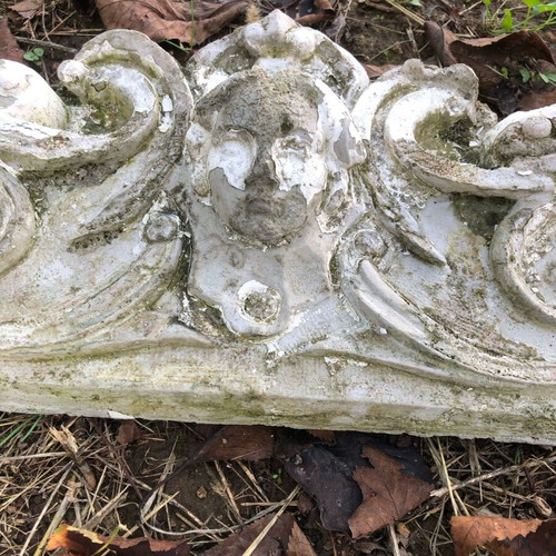 Old plaster pediment used with spiral motifs and human head