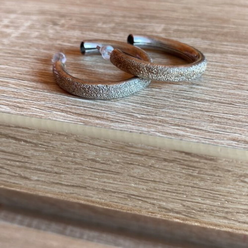 Pair of silver earrings used with textured design