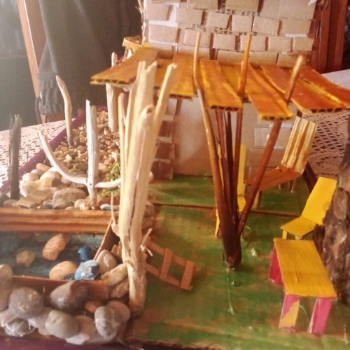Handmade decorative house with cardboard, pebbles and driftwood, new
