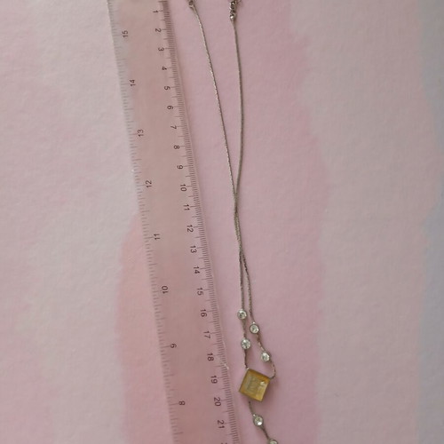 Silver necklace used with white stones and yellowish square