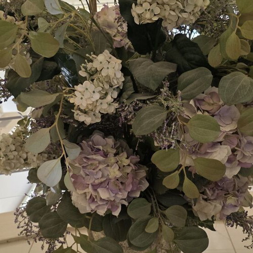 Artificial flower arrangement with hydrangeas and eucalyptus in clay floor vase
