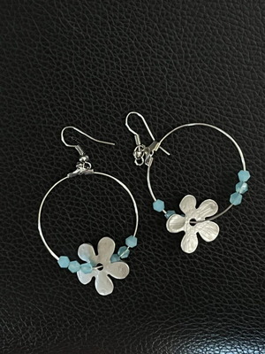 Metal hoop earrings with silver flower and blue beads