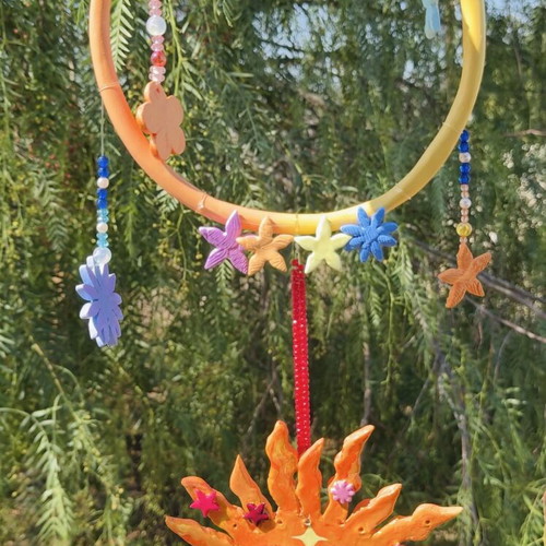 Handmade clay mobile with sun and flowers