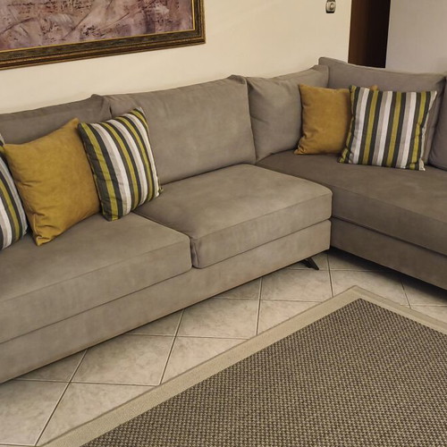Corner sofa like new in grey/beige taupe color with decorative pillows