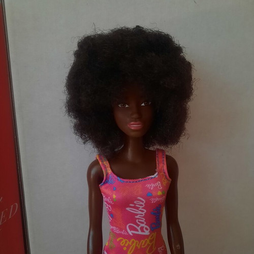 Barbie doll with afro hair and pink logo dress