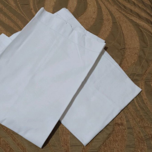 Set of 2 white pillowcases used for sleeping