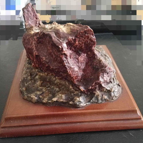 Decorative used piece with red mineral stone on wooden base