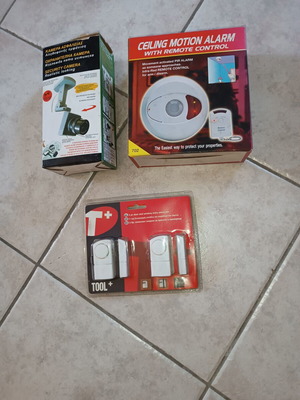 Security package used with ceiling motion alarm, door & window entry alarm, and realistic security camera