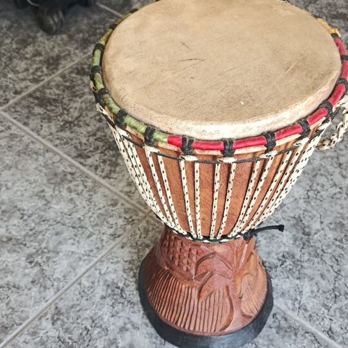 Wooden African drum with carved details and leather membrane
