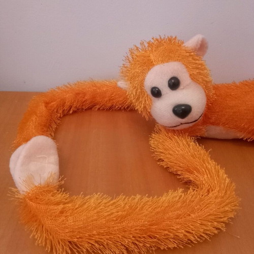 Stuffed monkey with scratches like new, orange color