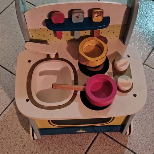 Wooden play kitchen with oven used, with pots and spoons