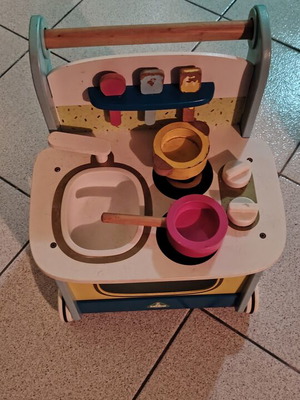 Wooden play kitchen with oven used, with pots and spoons