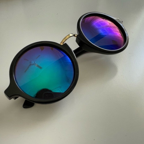 Sunglasses with round iridescent lens used, black frame with gold detail