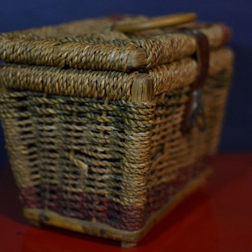 Vintage wicker storage basket used with leather strap and metal clasp