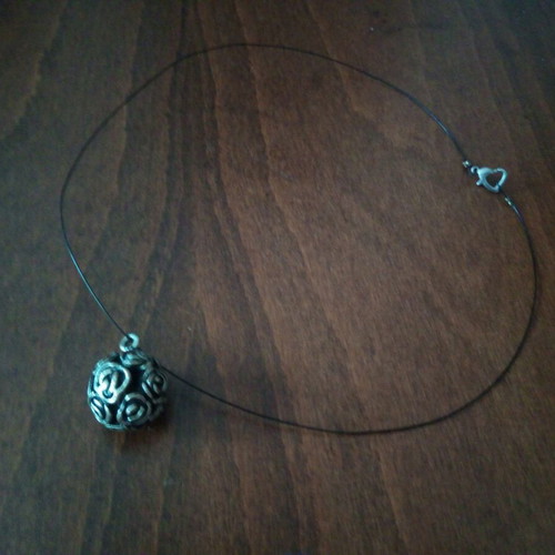 Pendant perforated sphere with heart clasp on leather strap used