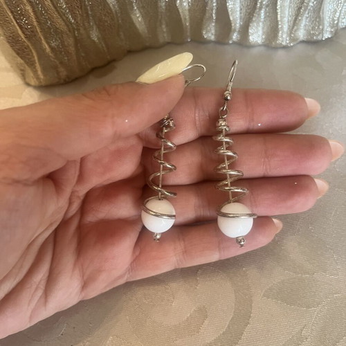 Silver dangling earrings with spiral design and white sphere