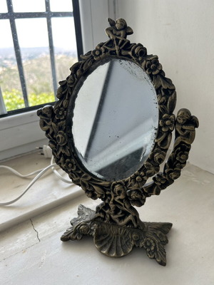 Vintage brass vanity mirror used with cherubs and floral carvings