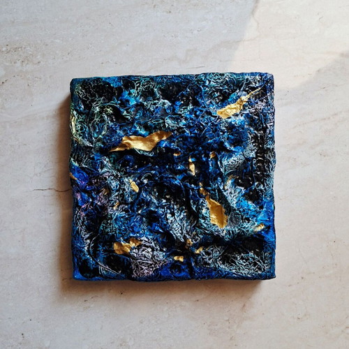 Abstract painting with blue and gold textured surface