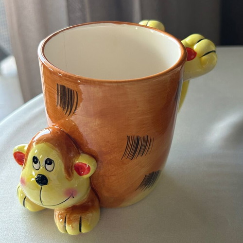 Vintage ceramic mug with embossed monkey design, used