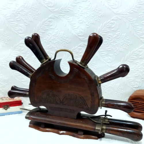 Wooden carved stand with used set of knives and forks